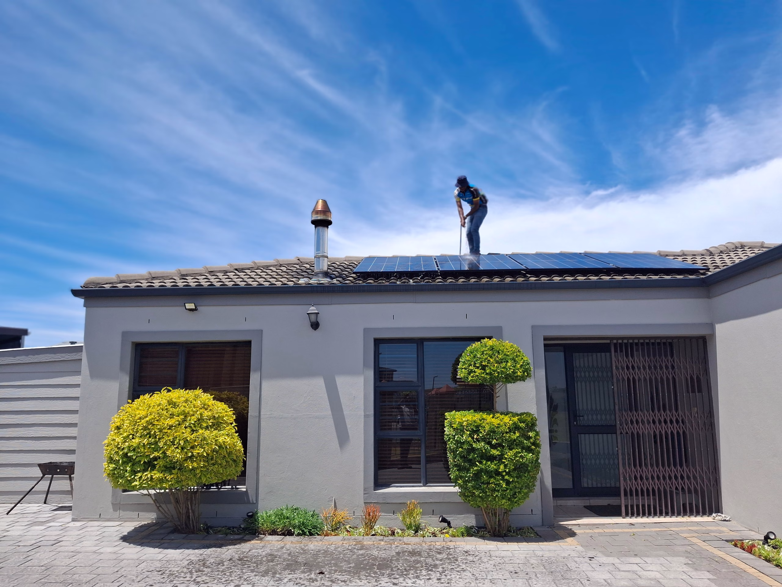 Worker installing solar panels on a residential roof